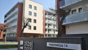 A modern building with a sign reading 'blizej morza' and 'kasprowcza 14'. - Cozy Studio | 400 m to the Beach, Gym, Balcony (Kołobrzeg)