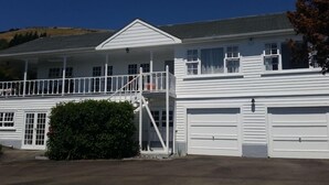 Ein zweigeschossiges Haus mit Balkon, Garage und gepflegtem Rasen.