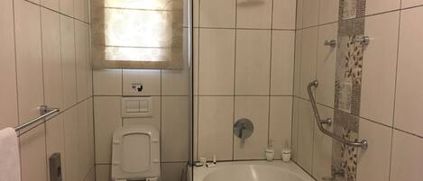 Un baño con inodoro, ducha y bañera.