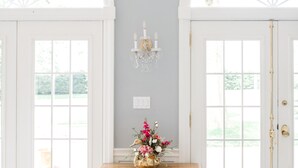A room with a marble floor, a wooden dresser with drawers, a chandelier, and two large arched windows. - Gorgeous Estate set in beautiful Lancaster County  (Bird in Hand)
