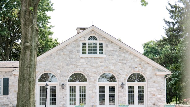 A stone building with arched windows and a central entrance. - Gorgeous Estate set in beautiful Lancaster County  (Bird in Hand)