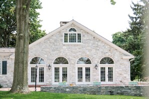 A stone building with arched windows and a central entrance.