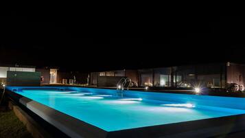 Una piscina al aire libre, tumbonas