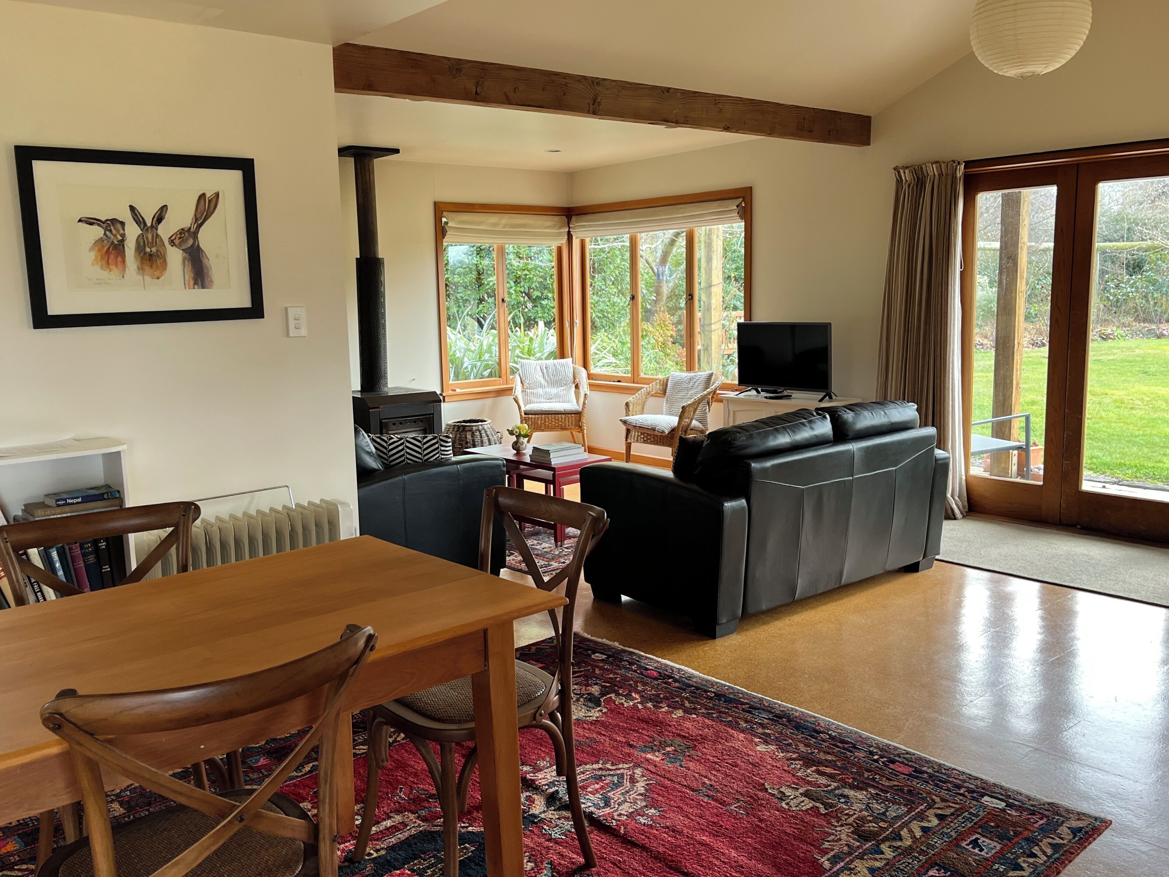 A living room with a fireplace, a sofa, a television, and a dining area with chairs and a table.