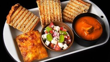 Grilled bread, a bowl of salsa, and a bowl of soup on a tray.
