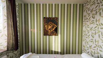 Quarto com cama, uma obra de arte na parede e janela com cortinas.