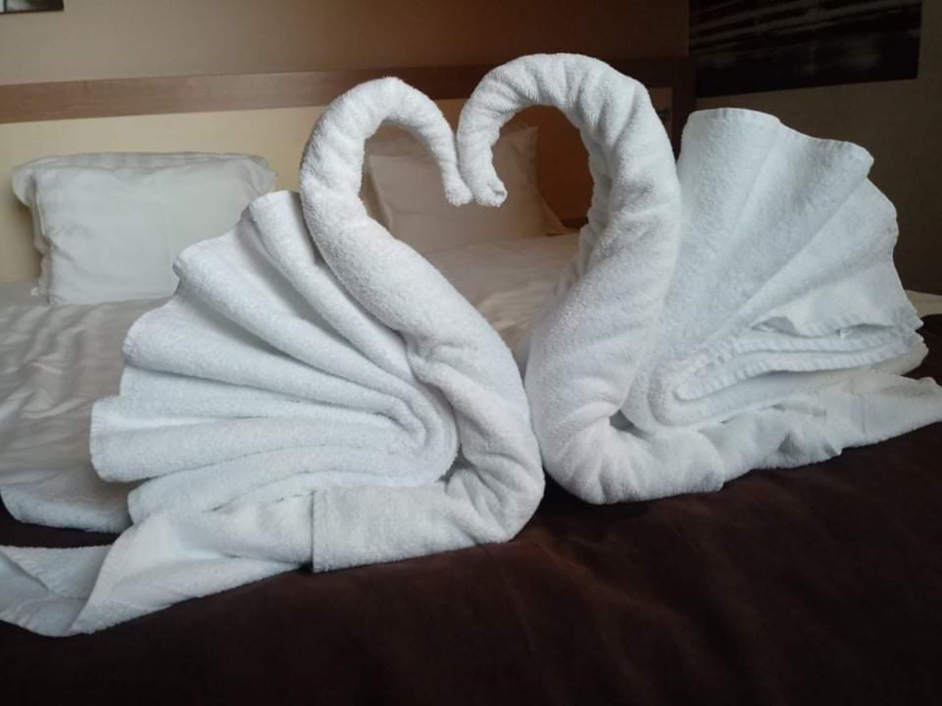 A bed with white pillows and a brown blanket.