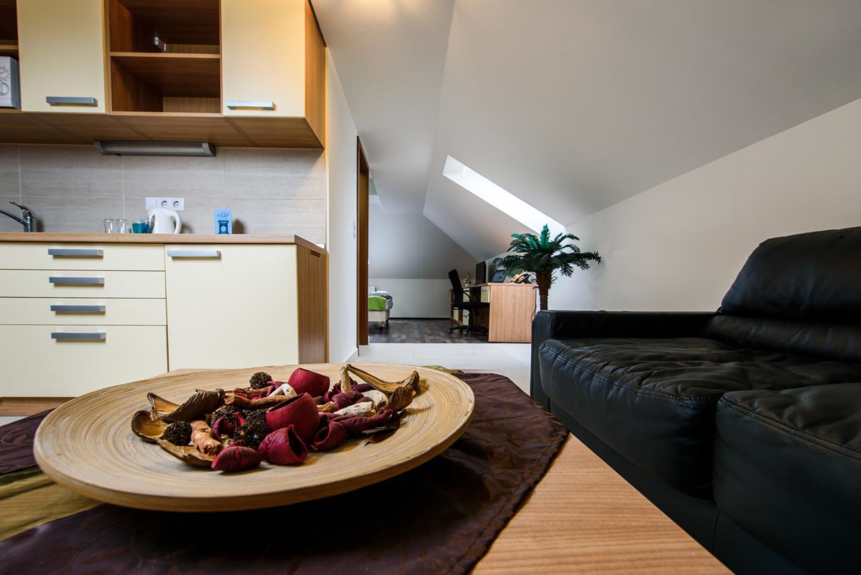 Een moderne keuken met houten kastjes en een eethoek met een ronde houten tafel.