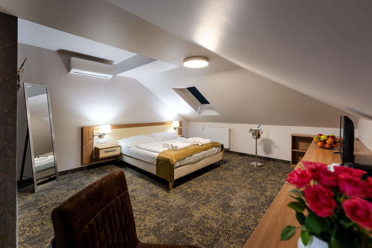 Une chambre d’hôtel avec un lit, une table de chevet, une lampe et un miroir.