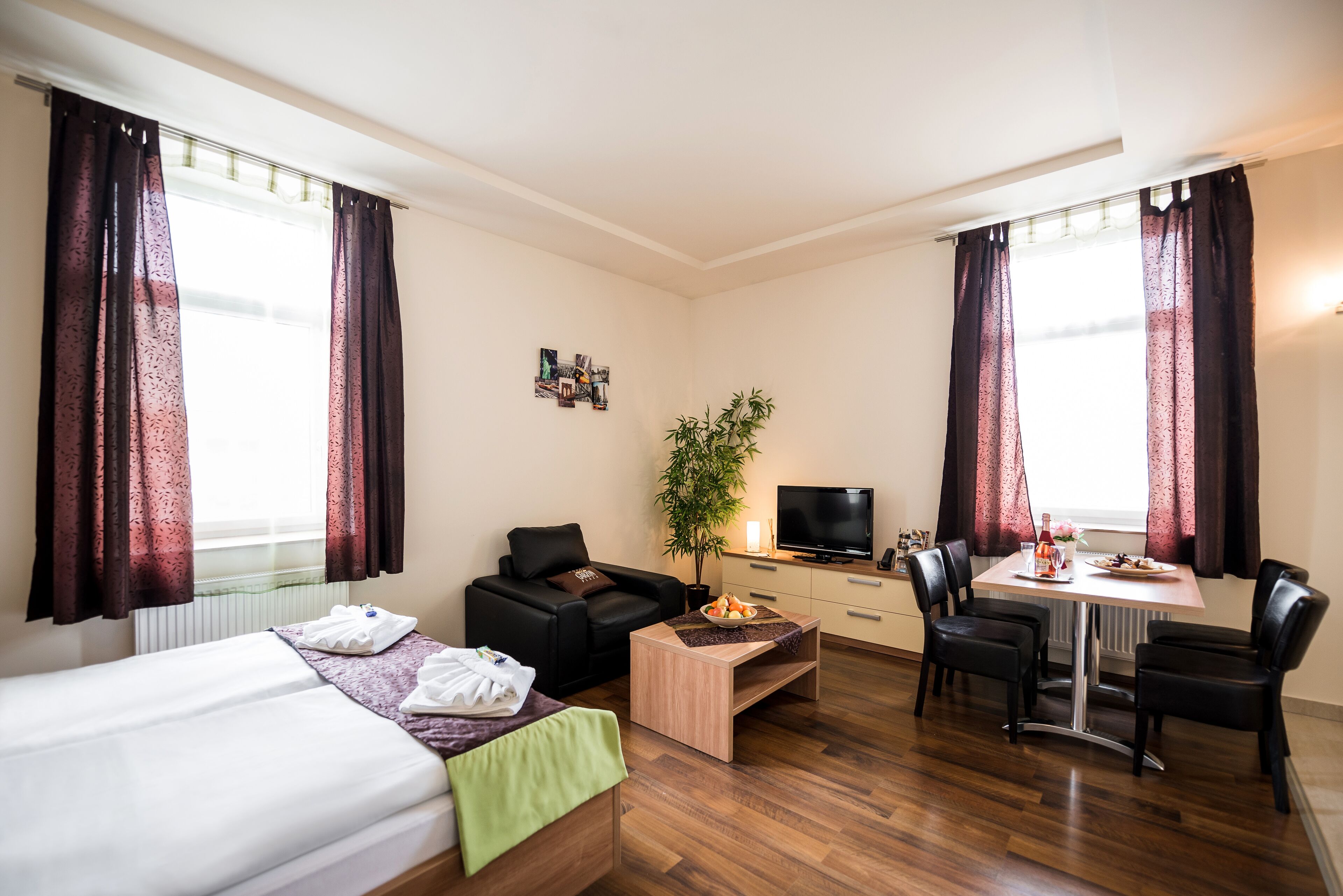 Une chambre d’hôtel comprenant un lit, un bureau, une télévision, une table et des chaises.