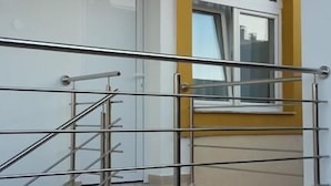 Eine moderne Treppe mit Metallgeländern, die zu einer oberen Etage führt.