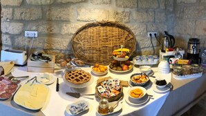 A buffet table with various food items and utensils, including a pie, cheese, and condiments. - Ai Pilieri di Bagnoli (Andria)