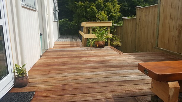 A wooden deck with potted plants and a wooden bench. - Peaceful, sunny, furnished - everything you need. (Johnsonville)