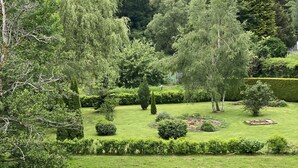 Un exuberante jardín con varios árboles y céspedes bien cuidados.