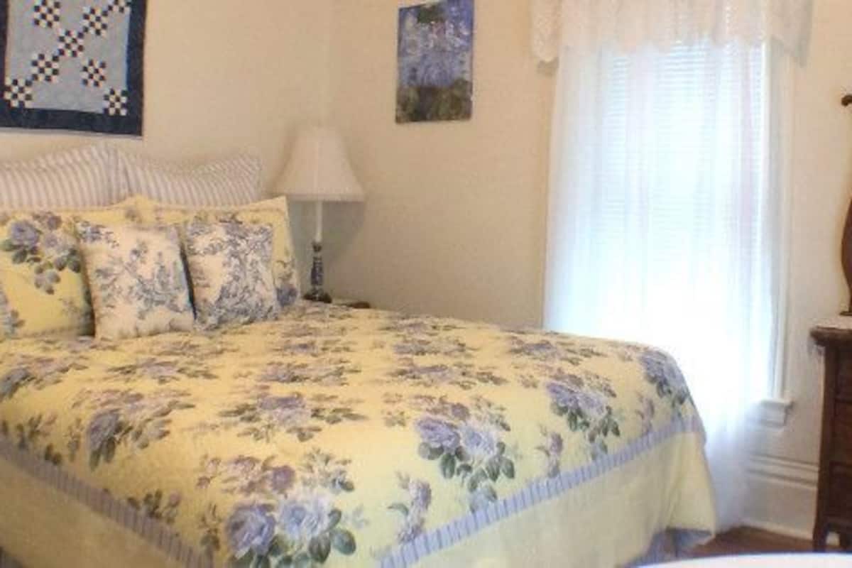 Un dormitorio con cama, cómoda, espejo y mesita de noche.