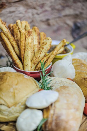 Variedad de panes y pasteles, incluyendo baguettes y croissants, dispuestos sobre una mesa de madera.