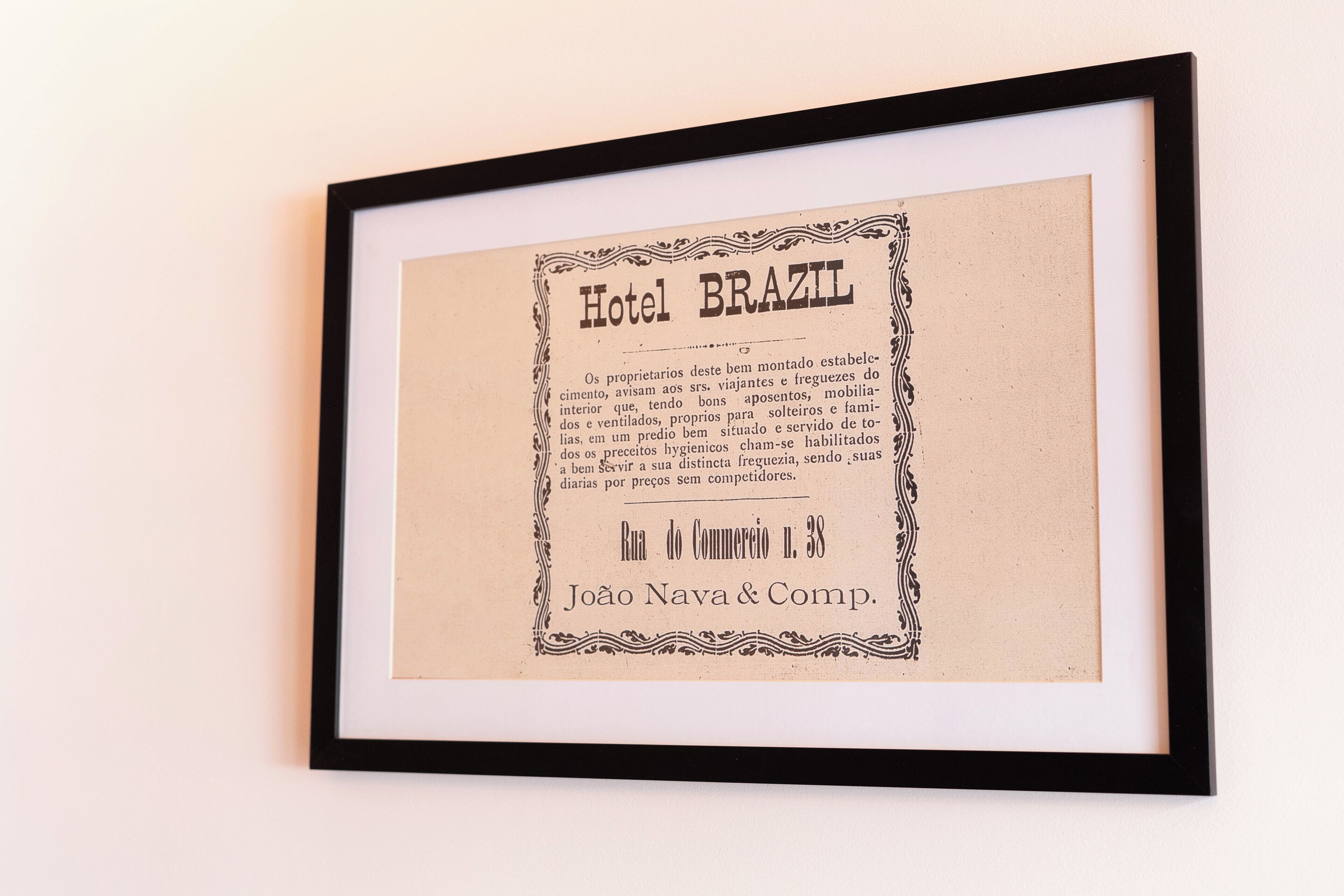 A framed historical document titled 'Hotel Brazil' with ornate borders, detailing amenities and services.