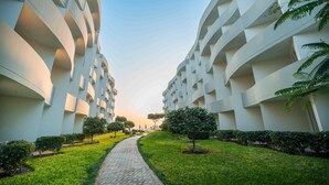 A pathway flanked by modern buildings with a clear sky. - Casa Andina Select Paracas (Paracas)