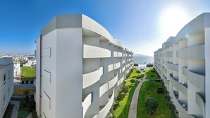 A modern hotel with a central courtyard, multiple balconies, and a view of the sea. - Casa Andina Select Paracas (Paracas)