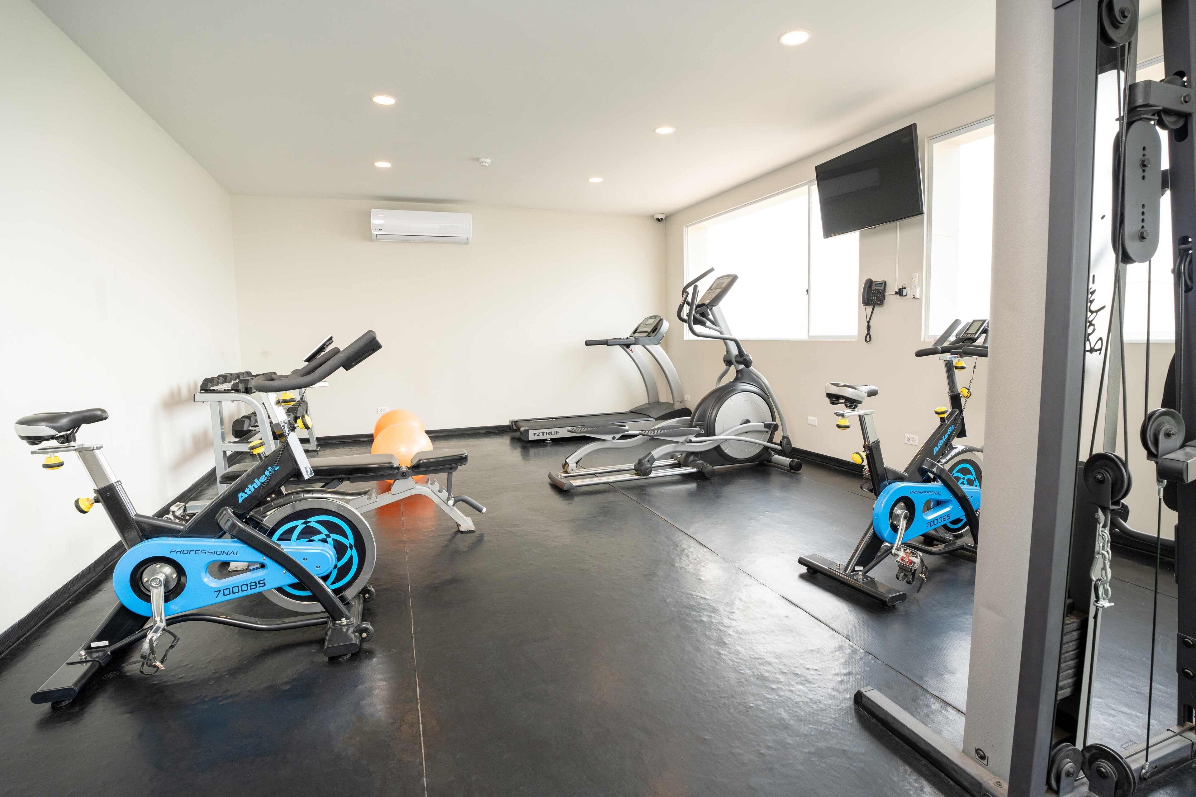 A gym with stationary bikes, treadmills, and weight machines.