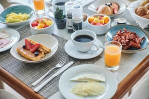 Un bufé de desayuno con diversos platos, como tostadas, fruta y bebidas.