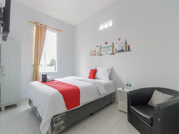 Een hotelkamer met een bed, een stoel, een nachtkastje en een decoratie aan de muur.