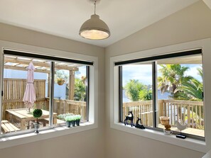 Enjoy the serene views of the outdoor patio from the comfort of your room, featuring a deck with a table and chairs.