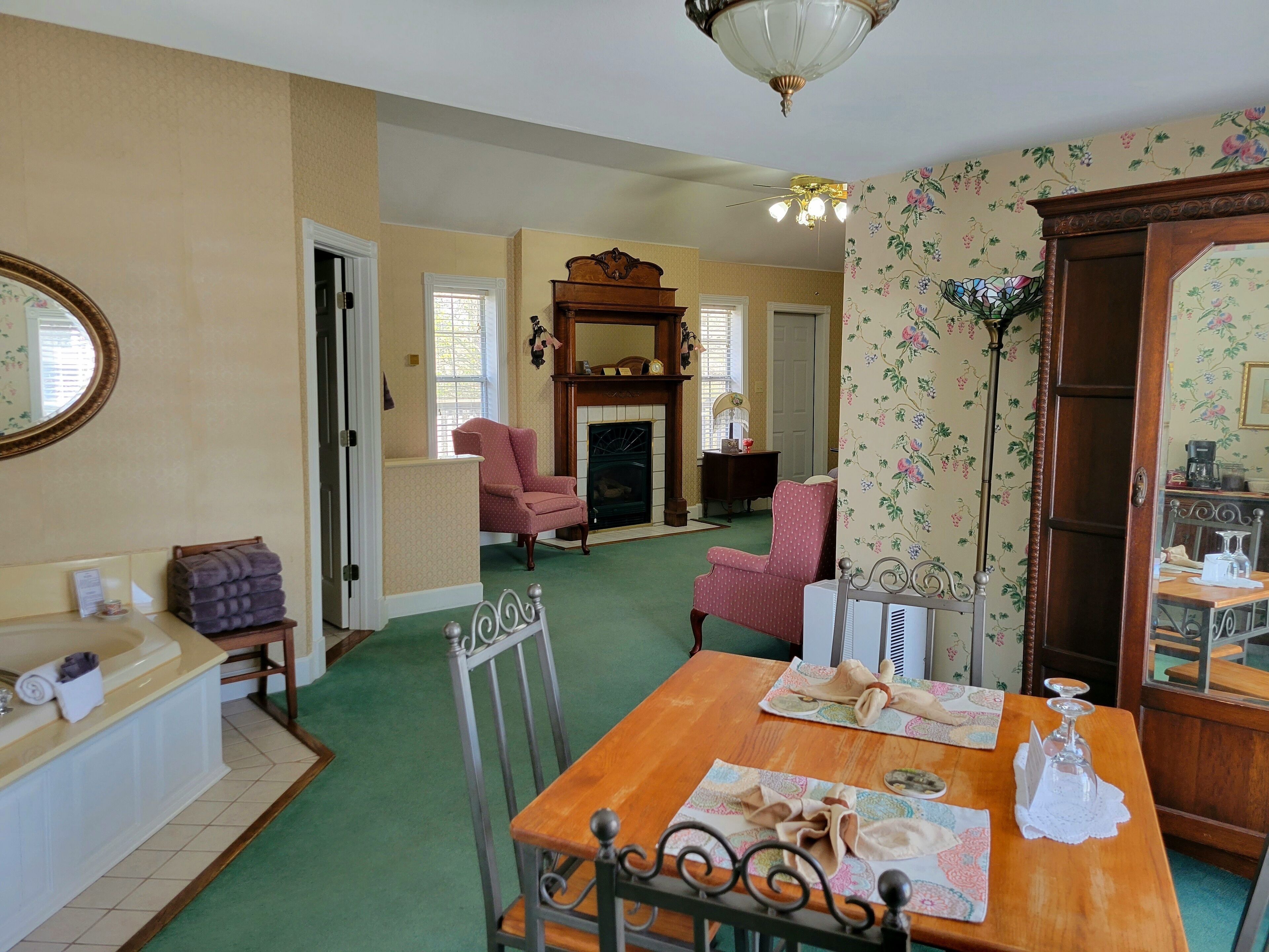 A dining area with a wooden table, chairs, and a fireplace.
