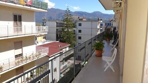 Ein Balkon mit Blick auf eine Stadtlandschaft und Berge.