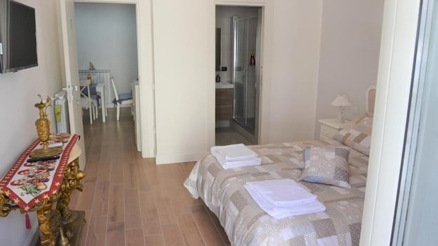Ein Schlafzimmer mit einem Bett, einem Nachttisch, einem Stuhl und einem kleinen Tisch mit einem dekorativen Gegenstand.