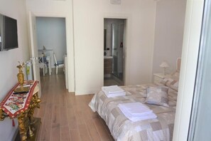 Une chambre à coucher comprenant un lit, une table de chevet, une chaise et une petite table sur laquelle est posé un objet décoratif.
