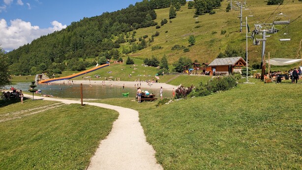 A scenic outdoor area with a water slide, a path leading to a wooden building, and a hill in the background. - Studio accredits 3clés the slopes Centre station free wifi (Les Deux-Alpes)