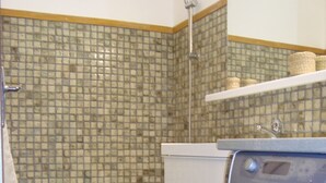 A compact laundry room with a washing machine, a bathtub, and a tiled shower area. - Studio accredits 3clés the slopes Centre station free wifi (Les Deux-Alpes)