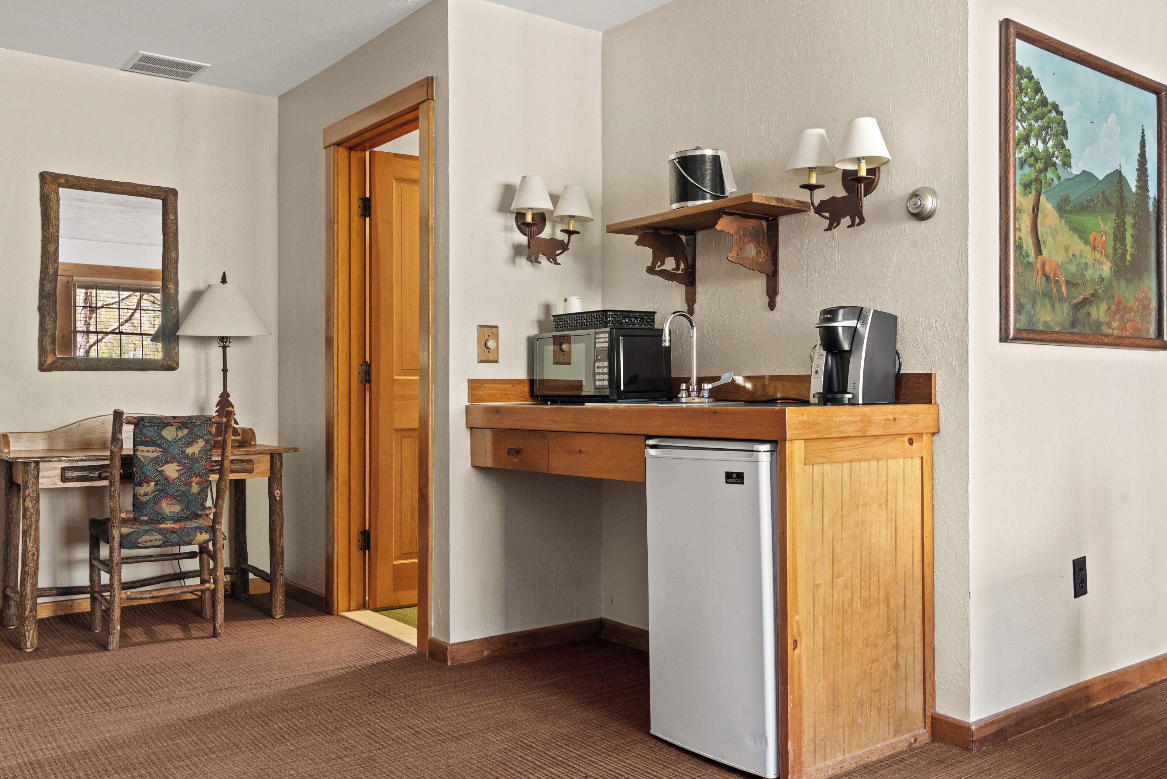 A compact kitchen with a microwave, coffee maker, and a refrigerator.
