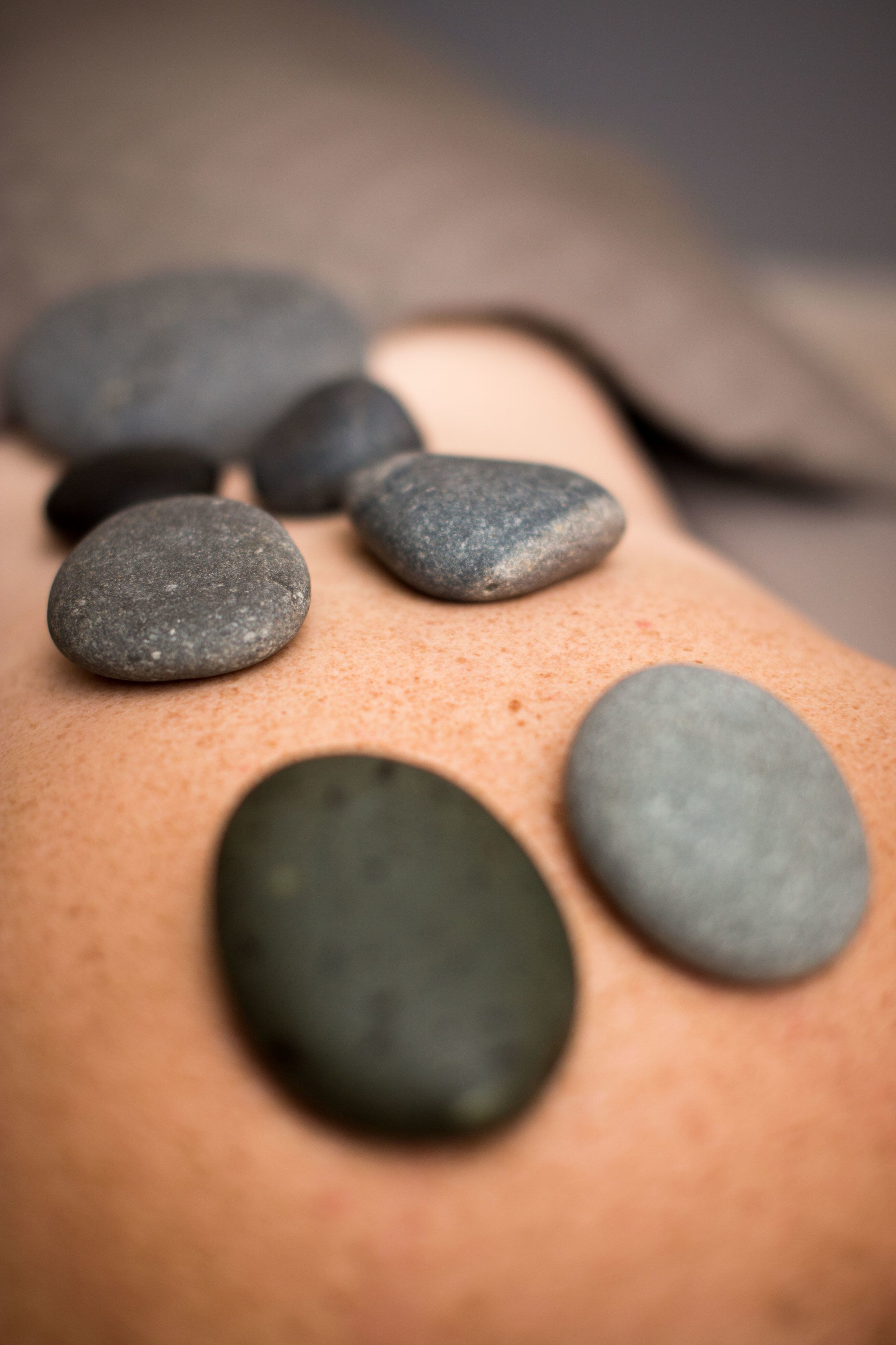 A close-up of smooth, round stones on a person's back.