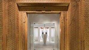 Un corridoio con elaborate decorazioni scolpite sulle pareti e un grande vaso al centro.