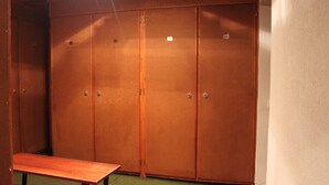 A room with a wooden bench and a large wardrobe with two doors. - Studio quiet with stunning views over the valley (Montvalezan)