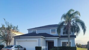 A two-story house with a garage, a driveway, and a well-maintained lawn. - 5 Bedroom family home in gated community, near Disney. (Davenport)