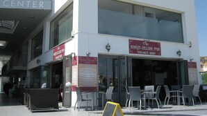 A building with a sign reading "CENTER" and another sign for "The King's Cellar Pub." - Luxury 5 star villa private pool and patio in quiet village, Larnaca. (Oroklini)
