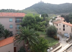 A residential area with buildings, a hill, and a road.