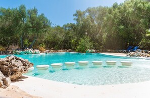 A clear pool with steps leading into it, surrounded by rocks and trees. - Rural apartment in the center of Mallorca for 2, 4 and 6 people (Sineu)