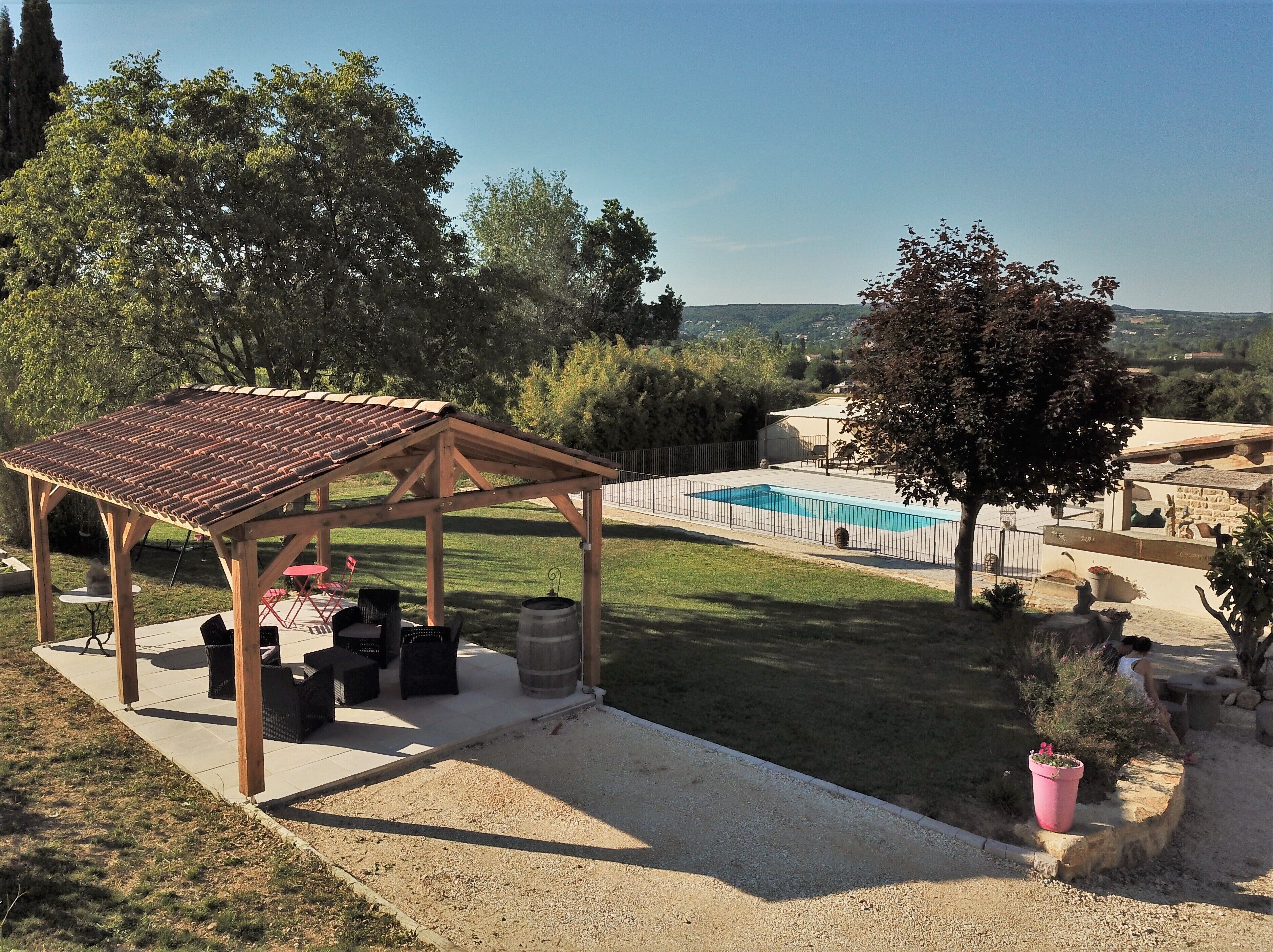 Un espace extérieur abrité, doté d’une piscine, et entouré d’une clôture et d’arbres.