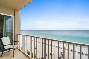 A balcony with a view of a beach and ocean.