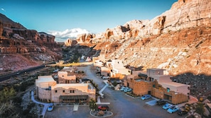 Un pueblo desértico con una calle central, edificios de techos planos y montañas al fondo.