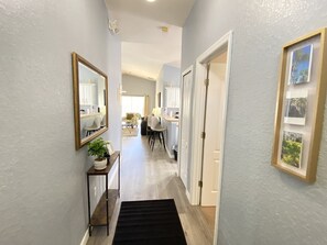 Stunning hallway leads to a dining area with a table and chairs.