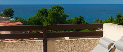 Un balcon avec deux fauteuils confortables donnant sur une vue imprenable sur la mer.