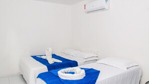 A hotel room with two beds, each with a blue and white blanket, and a white towel on the beds. - Pousada Sereias de Maragogi (Maragogi)