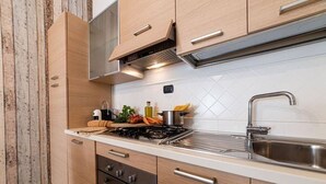 Une cuisine moderne avec des meubles en bois, un évier en acier inoxydable et une cuisinière à gaz.