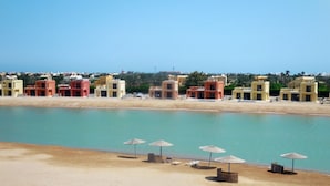 Ein Küstenhotel mit bunten Gebäuden, einem Sandstrand und ruhiger Seele.