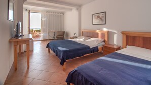 A hotel room with two beds, a desk, a chair, and a balcony with a view. - Levantin Inn One Third Room N2 Sea Side (Budva Municipality)